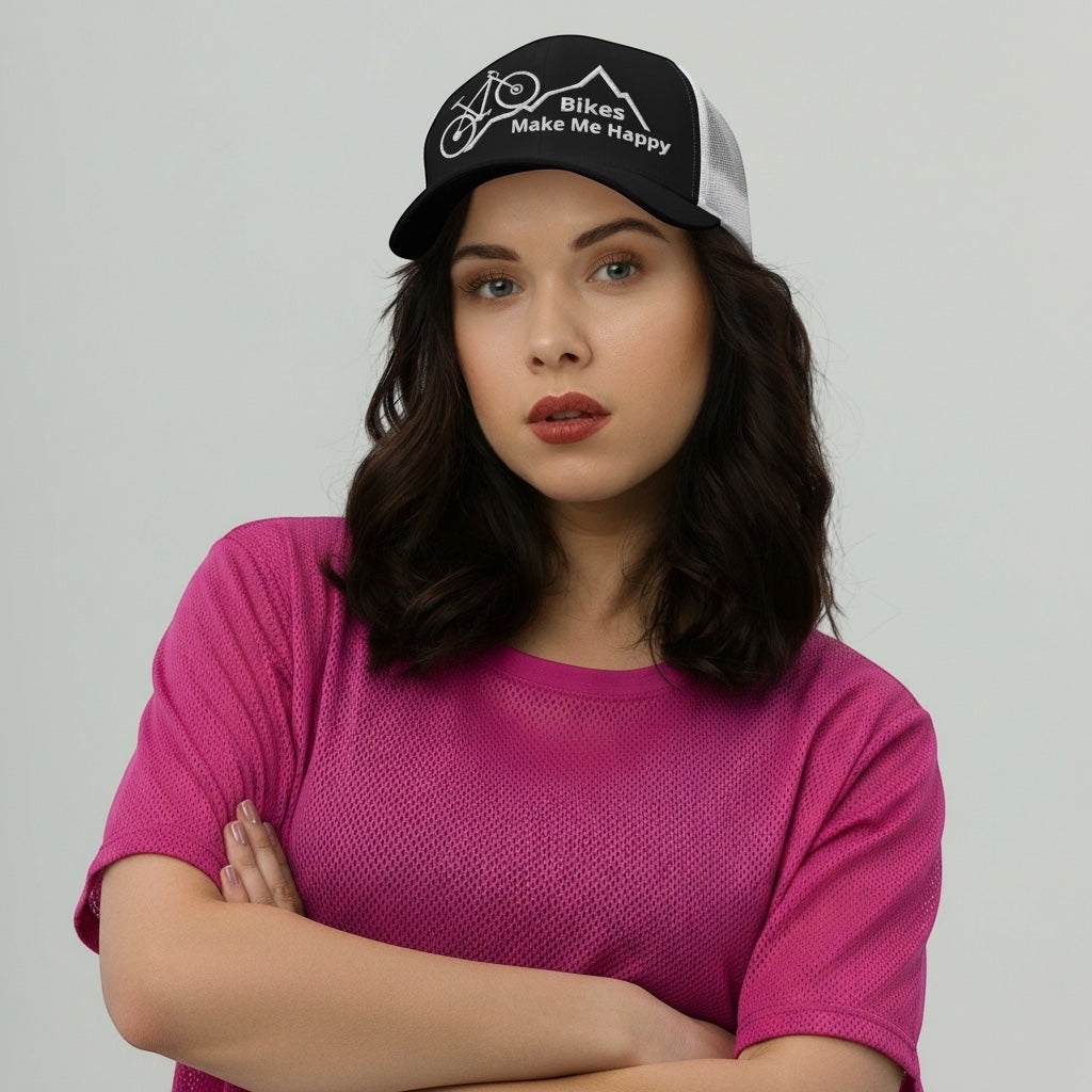 A woman wearing a Bikes Make Me Happy black and white mesh trucker hat with a mountain and bicycle graphic.