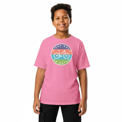 A smiling boy wearing a pink Bikes Make Me Happy cotton youth t-shirt with a colorful circular bicycle graphic.