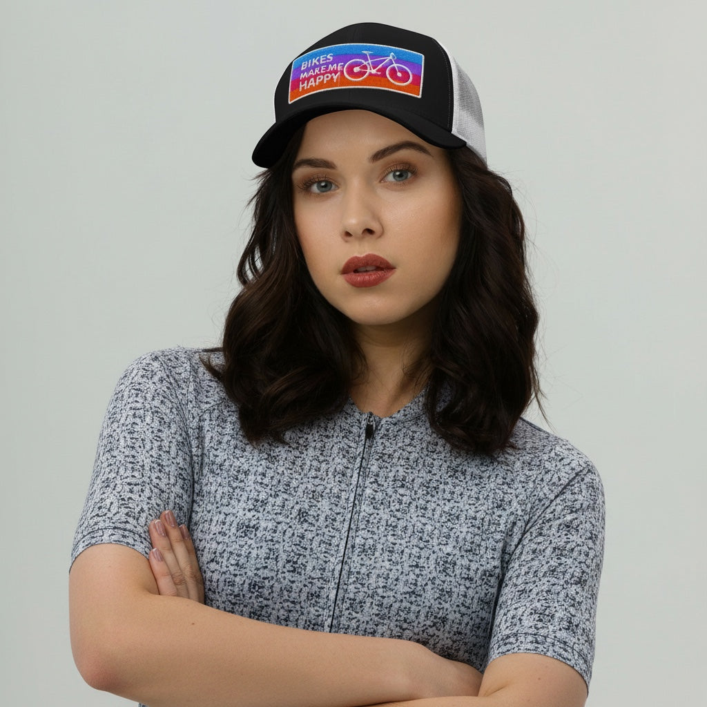 A woman wearing a Bikes Make Me Happy trucker hat with a colorful embroidered badge and mesh back.