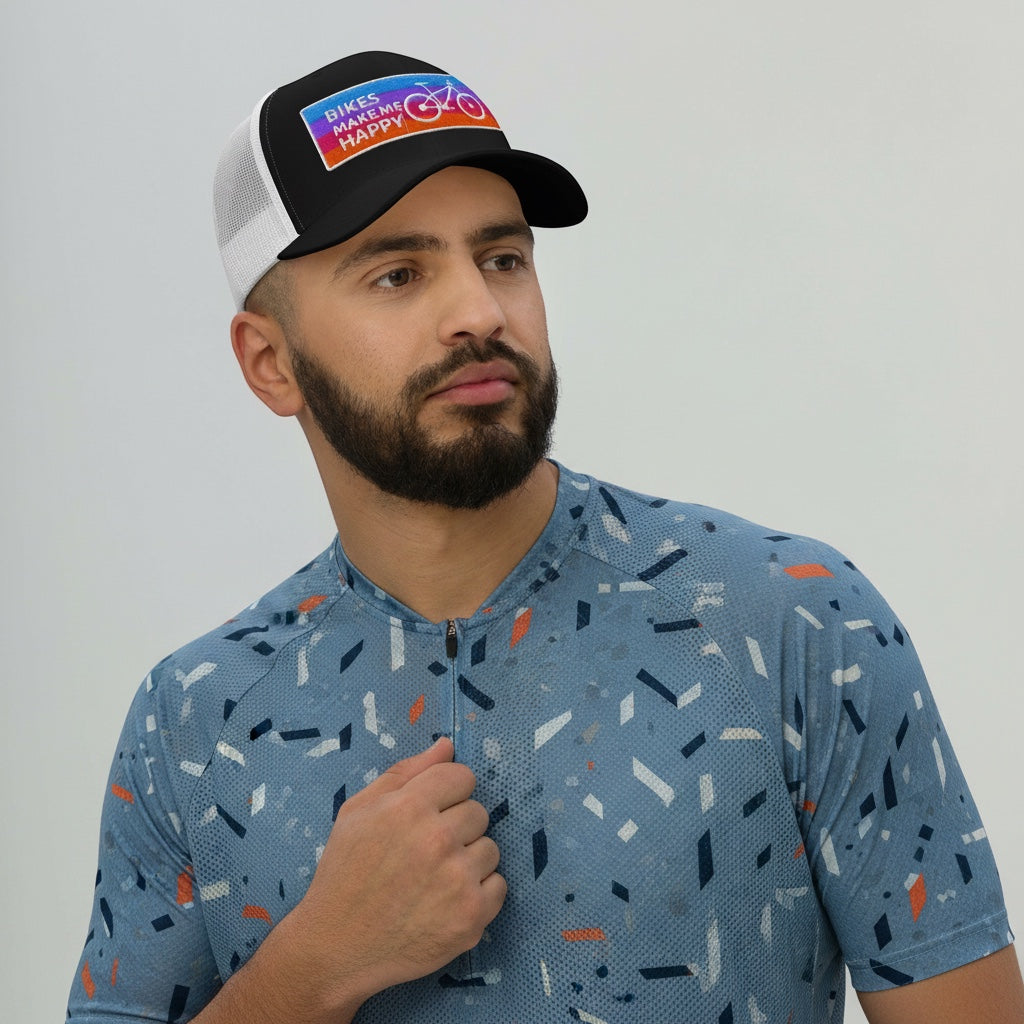Bikes Make Me Happy trucker hat with a colorful embroidered badge, black front, and white mesh back on a male model.